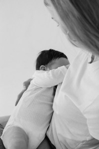 mother breastfeeding baby while talking to telehealth psychiatrist about anxiety medication